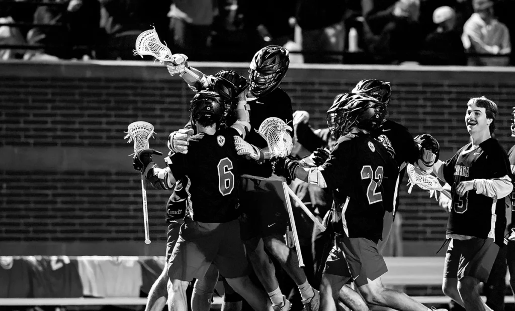 A group of Canadian Lacrosse field players jump atop one another in celebration after a big play